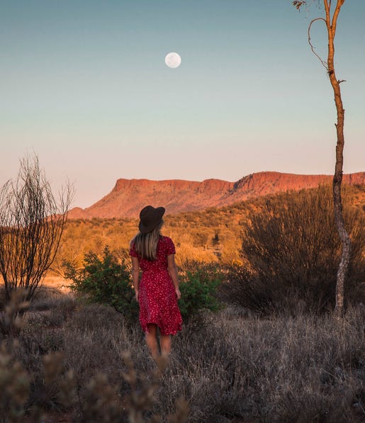 woman taking in scenic view and moon in the west macdonnell ranges