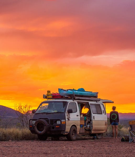Girl with a van camping at sunset at Tjoritja-West MacDonnell NationalPark
