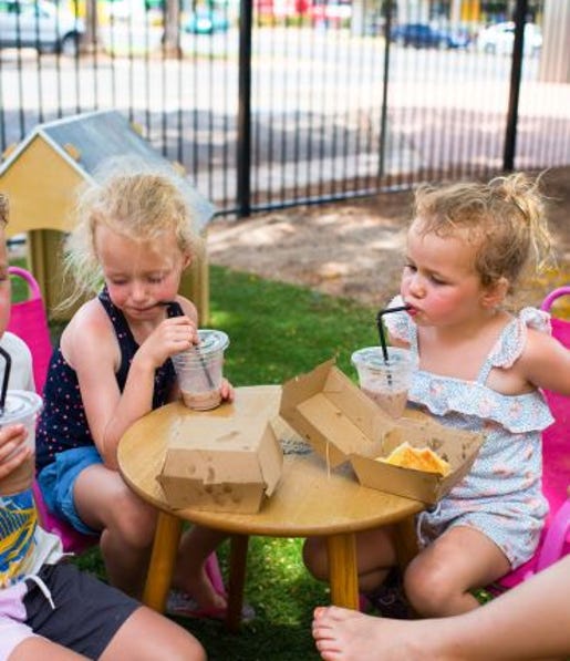Children drinking iced chocolates at the Black Russian Caravan Bar in Katherine